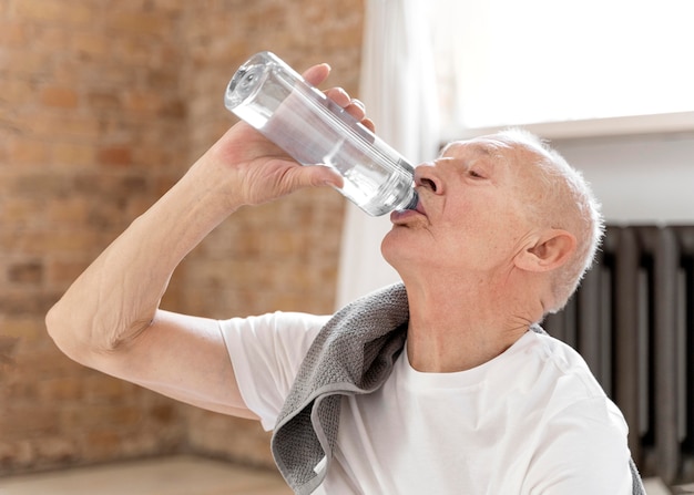 Trinkwasser des älteren Mannes des mittleren Schusses