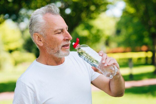 Trinkwasser des alten Mannes der Seitenansicht