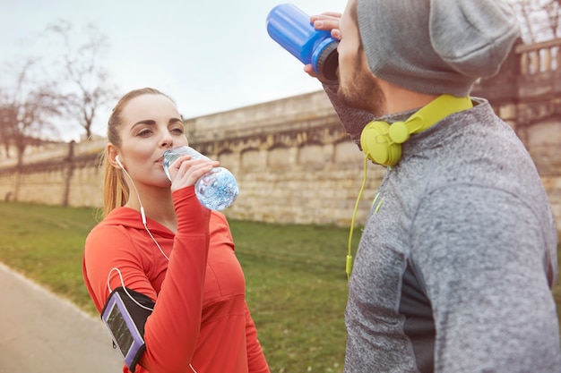 Trinkwasser des glücklichen Paares nach dem Training