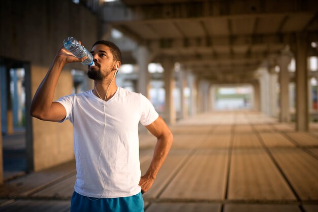 Trinkwasser des jungen sportlichen Athleten nach hartem Training