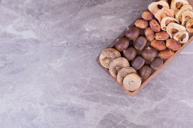 Trockene Früchte auf einer Holzplatte auf dem Stein