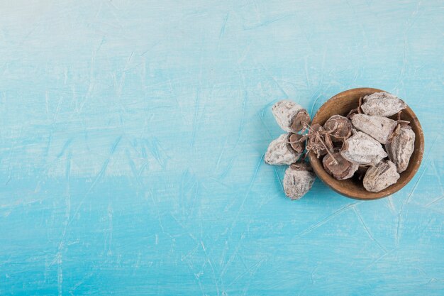 Trockene Pflaumendatteln in einer hölzernen Untertasse