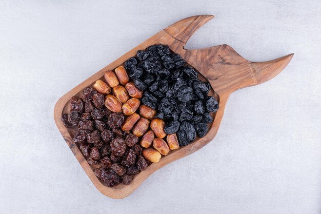 Trockenfrüchte mit Datteln und Kirschen auf einer Holzplatte. Foto in hoher Qualität