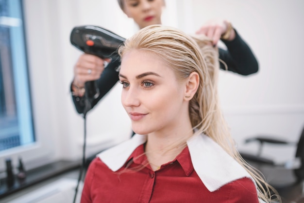 Trocknendes Haar der Frau des jungen Mädchens