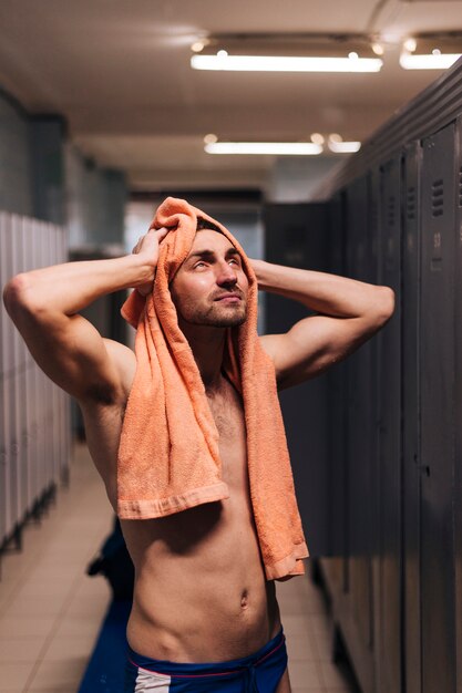 Trocknendes Haar des männlichen Schwimmers des hohen Winkels mit Tuch