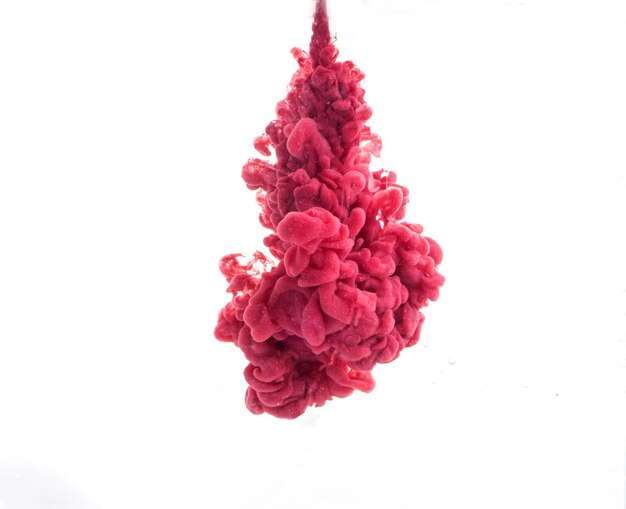 Tropfen roter Farbe fallen auf dem Wasser