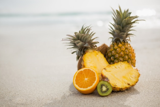 Tropische Früchte gehalten auf Sand