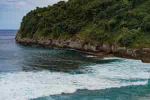 Kostenloses Foto tropischer hintergrund, strand mit blauem wasser, wellen brechen auf stein