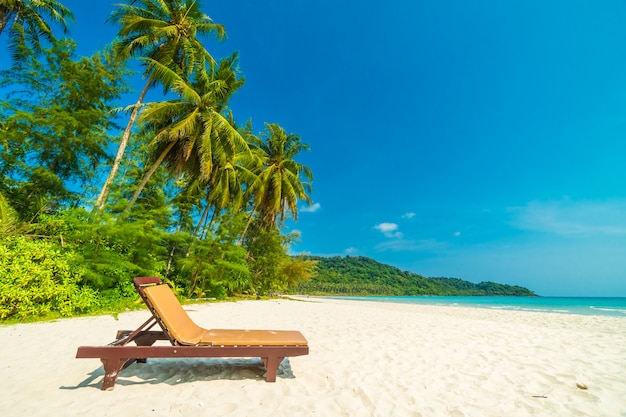 Tropischer Strand und Meer der schönen Natur mit Stuhl- und KokosnussPalme auf Paradiesinsel