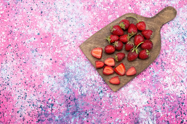 Ttop Ansicht frische rote Erdbeeren weich und saftig auf dem rosa Schreibtisch milde Beerensaftfarbe