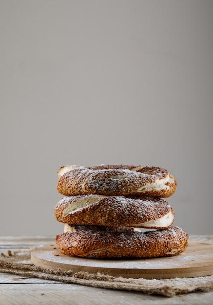 Türkische Bagel-Seitenansicht auf einem Schneidebrett und einer Holzoberfläche, Raum für Text