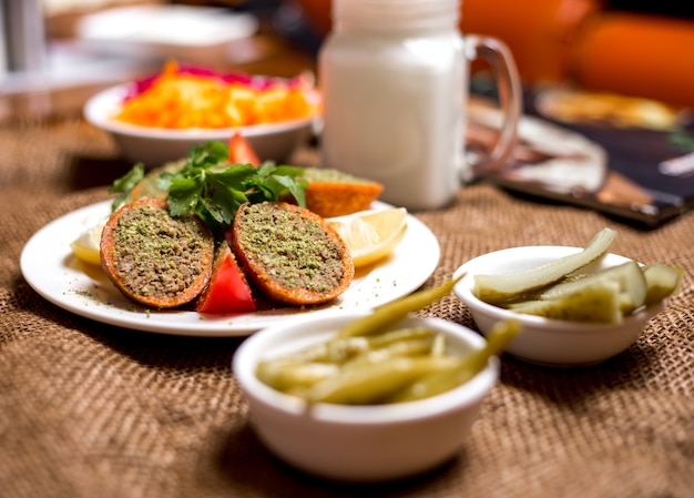 Türkische gefüllte Fleischbällchen ichli kofte serviert mit Zitronentomate und Petersilie