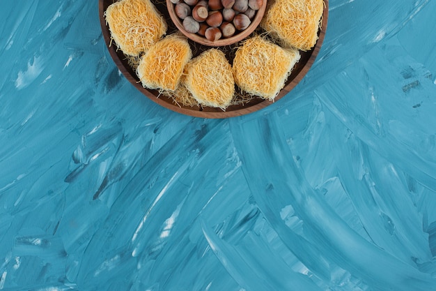 Türkische Köstlichkeiten mit Macadamianüssen auf einem dunklen Holzteller.