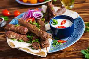 Kostenloses Foto türkische und arabische traditionelle ramadan-mischungskebabplatte. kebab adana, huhn, lamm und rindfleisch auf lavashbrot mit soße. ansicht von oben