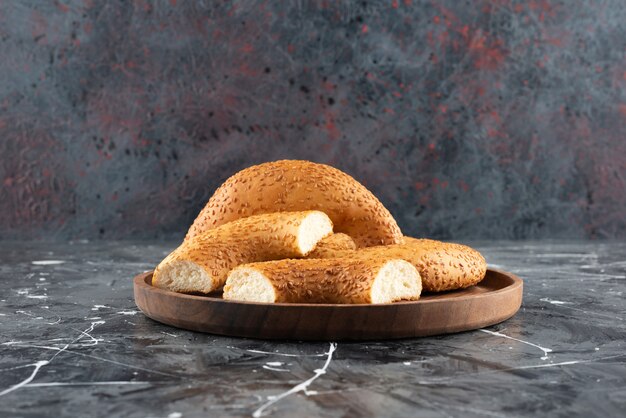 Kostenloses Foto türkischer traditioneller bagel simit in einer hölzernen platte auf einer marmoroberfläche