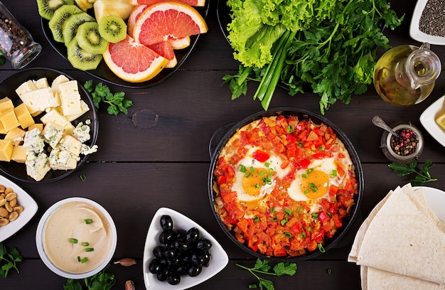 Türkisches Frühstück. Shakshuka, Oliven, Käse und Obst.