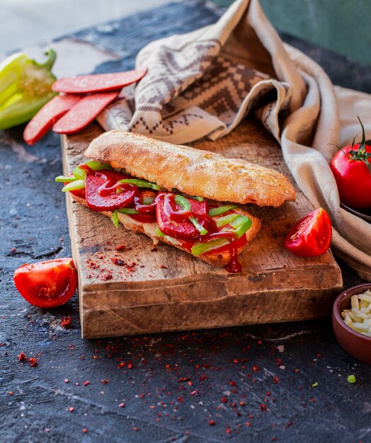 Türkisches sucuk ekmek im Stangenbrot auf einem Holztisch.