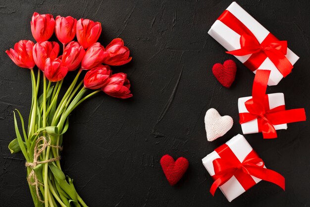 Tulpen und Geschenke auf schwarzem Hintergrund