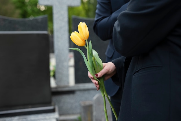 Tulpen werden auf dem Friedhof zu einem Grab gebracht