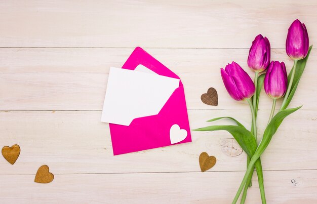 Tulpenblumen mit leerem Papier im Umschlag
