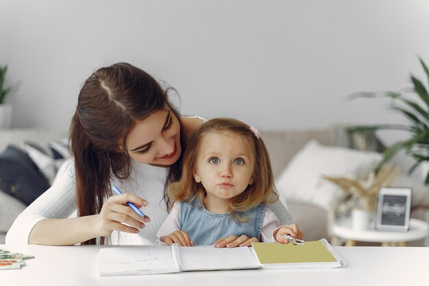 Tutor mit dem kleinen Mädchen, das zu Hause studiert