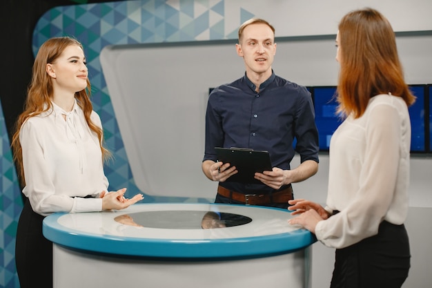 TV-Gameshow mit zwei Teilnehmern, die Fragen beantworten oder Rätsel lösen und Moderator. Lächelnde Frauen nehmen am Fernsehquiz teil.