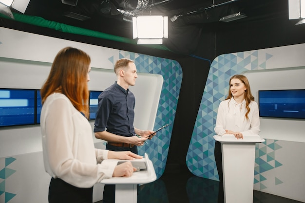 TV-Gameshow mit zwei Teilnehmern, die Fragen beantworten oder Rätsel lösen und Moderator. Lächelnde Frauen nehmen am Fernsehquiz teil.