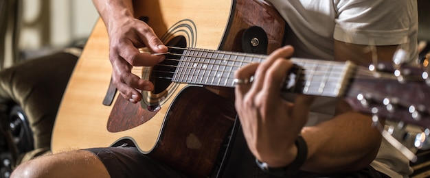 Typ, der Akustikgitarre spielt