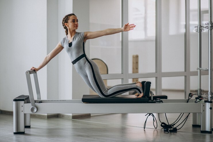 Kostenlose Foto übendes pilates der frau in einem pilates reformer