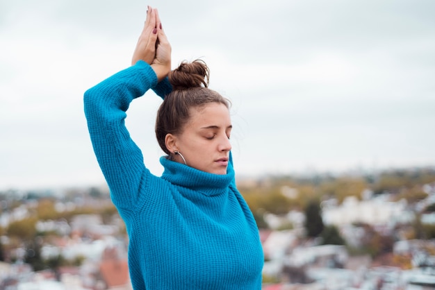 Kostenloses Foto Übendes yoga des entspannten mädchens im freien