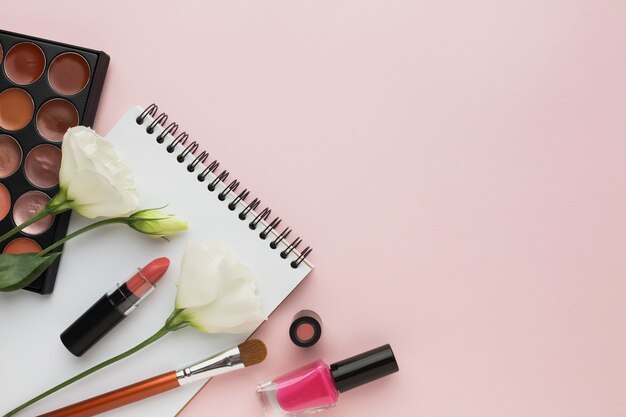 Über Ansichtrahmen mit Make-upprodukten und Blumen