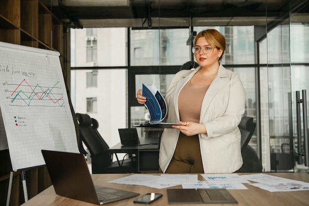 Kostenloses Foto Übergroße frau, die in einem professionellen geschäftsbüro arbeitet