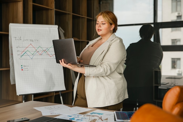 Kostenloses Foto Übergroße frau, die in einem professionellen geschäftsbüro arbeitet