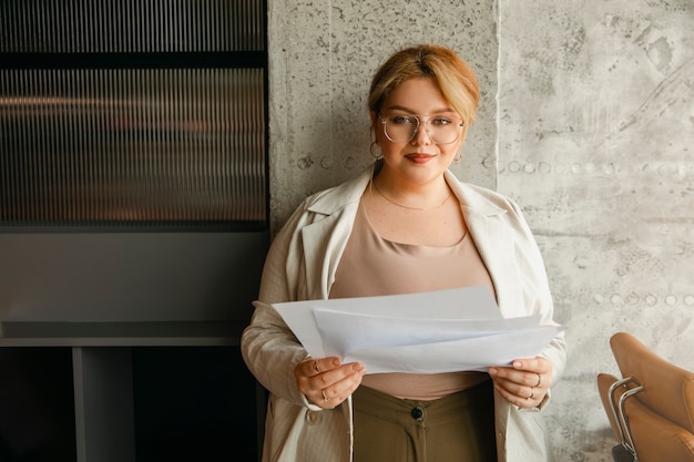 Kostenloses Foto Übergroße geschäftsfrau, die in einem professionellen büro arbeitet