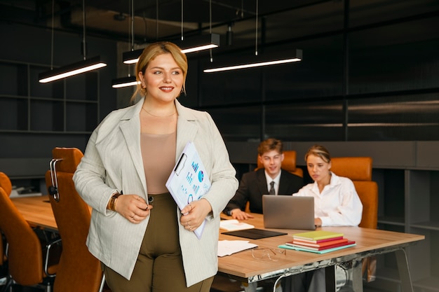 Kostenloses Foto Übergroße geschäftsfrau, die in einem professionellen büro arbeitet