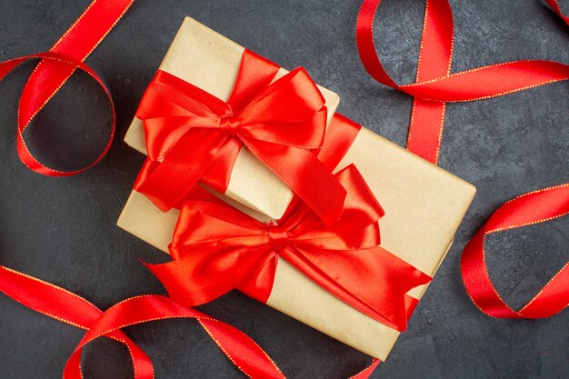 Überkopfansicht der schönen Geschenke mit rotem Band auf dunklem Hintergrund