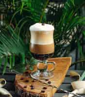 Kostenloses Foto Überlagerter kaffee mit sahne und kaffeebohnen auf rustikalem hölzernem brett