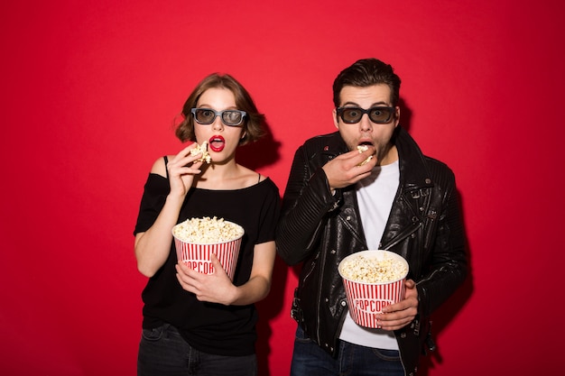 Kostenloses Foto Überraschte punkpaare, die popcorn essen und schauen