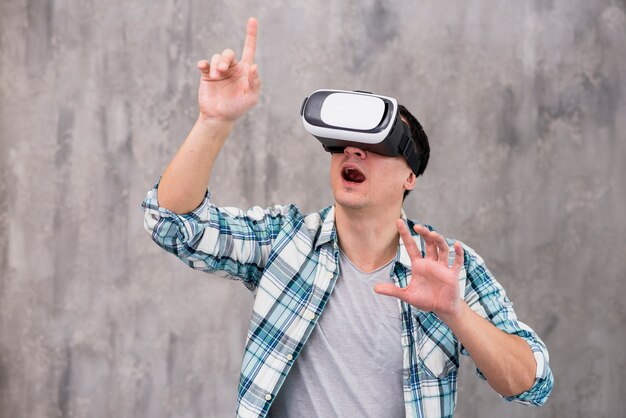 Überraschter junger Mann im VR-Kopfhörer