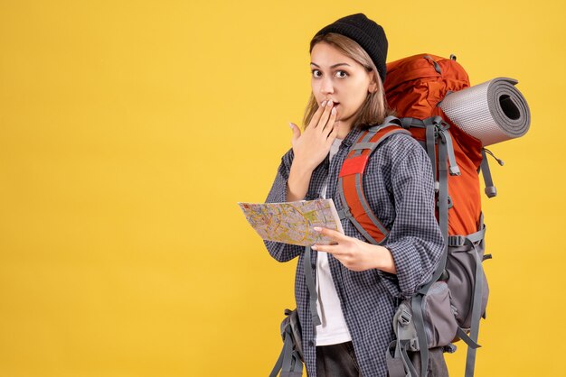 überraschter junger Reisender mit Rucksack mit Karte