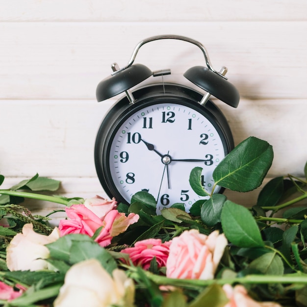 Kostenloses Foto uhr und schöne rosen