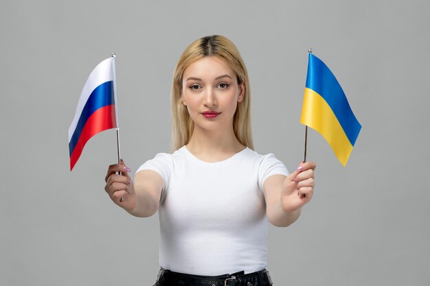Ukraine russischer Konflikt blondes süßes Mädchen mit rotem Lippenstift und russischer ukrainischer Flagge ernst