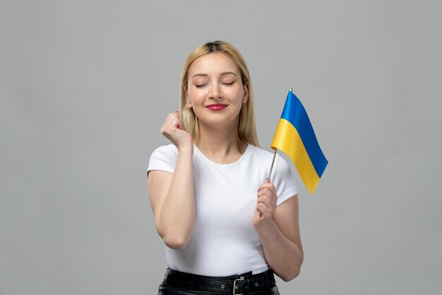 Ukraine russischer Konflikt blondes süßes Mädchen mit rotem Lippenstift und ukrainischer Flagge aufgeregt