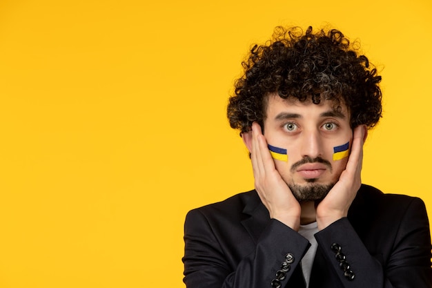 Ukraine russischer Konflikt junger Mann im schwarzen Blazer mit ukrainischer Flagge Nahaufnahme mit Gesicht