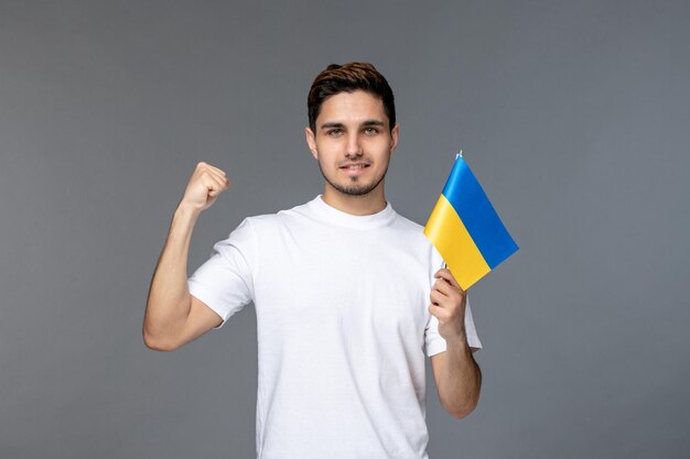 Ukraine-Russland-Konflikt mutiger süßer gutaussehender Kerl im weißen Hemd mit dem Zeigen von Stärke