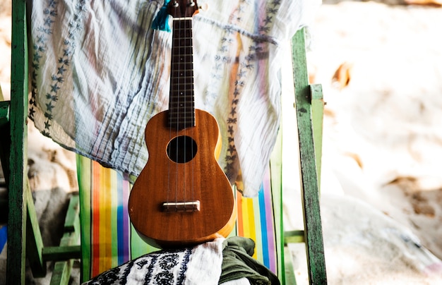 Ukulele auf Klappstuhl am Strandurlaub