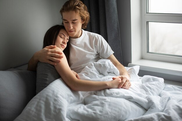 Umfassungsfreundin des Mannes während im Bett