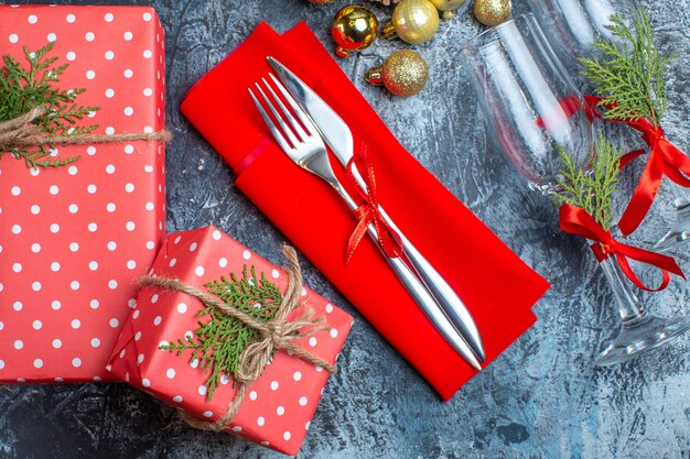 Umgefallene Glasbecher und Besteckset Dekorationszubehör Geschenkbox und Weihnachtssocke auf dunklem Hintergrund