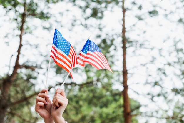 Unabhängigkeitstagkonzept mit der Frau, die zwei amerikanische Flagge hält