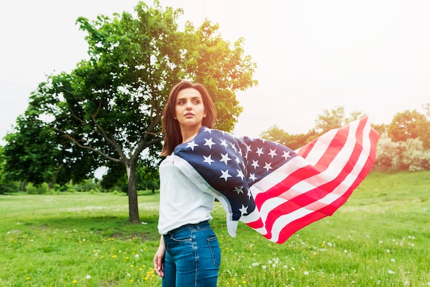 Unabhängigkeitstagkonzept mit Frau und amerikanischer Flagge